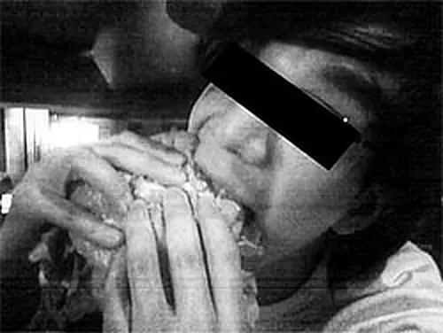 black and white photo of an anonymized kid eating a burger or something similar.